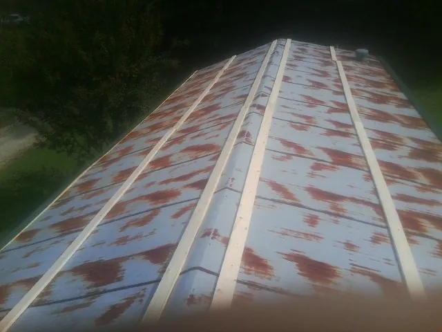 Rusted metal roof panels with new wood purlins before replacement — Storm Damage Roof Repair in Steinhatchee by Roofing Brothers
